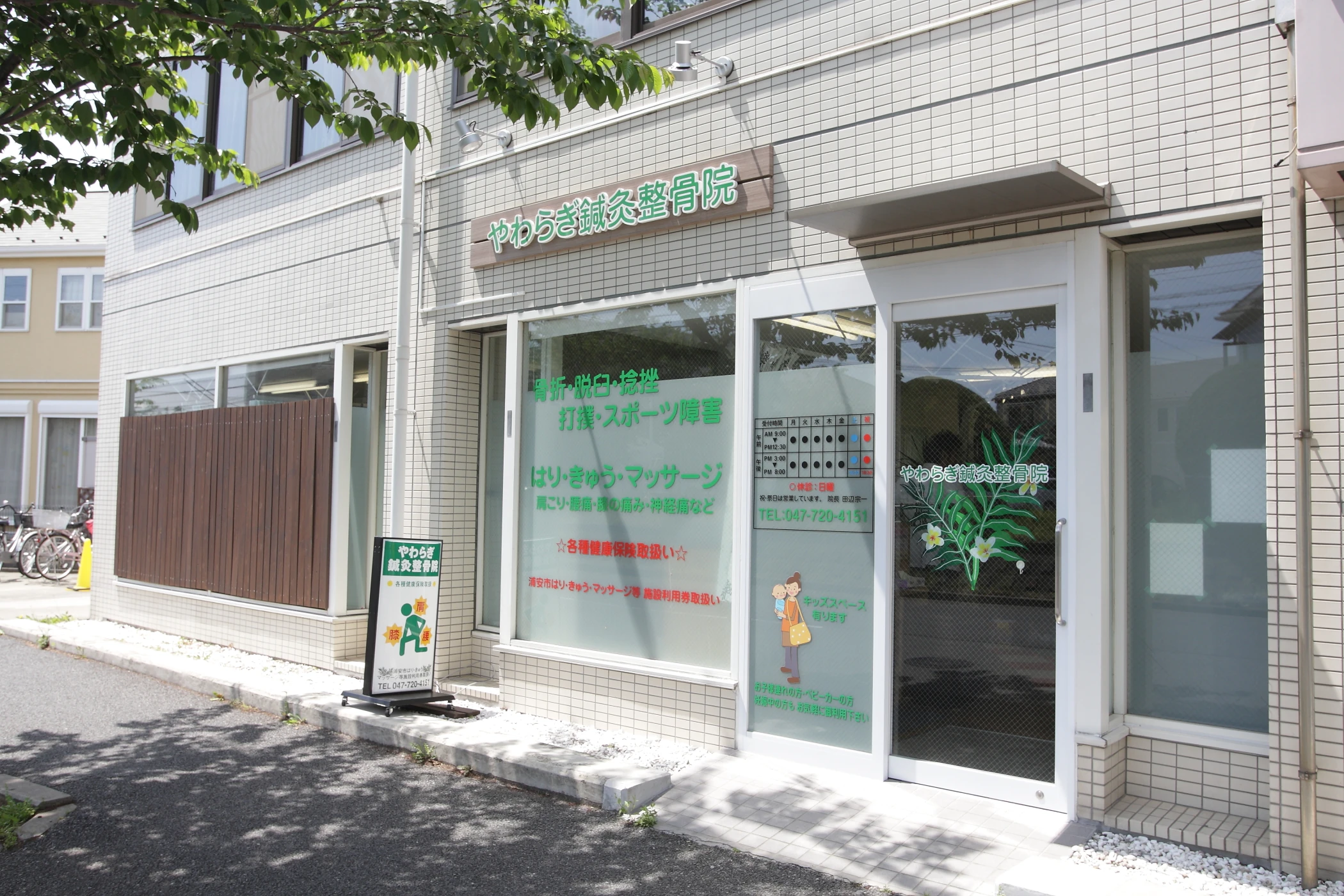 やわらぎ鍼灸整骨院の外観。緑の文字の看板とロゴ入りの入口